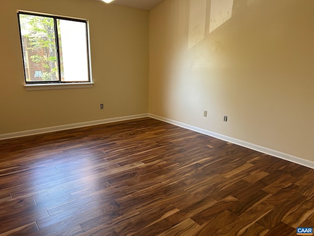 unfurnished room featuring dark wood-style floors and baseboards