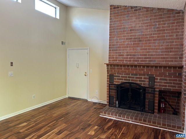 125 Turtle Creek Rd Unit 9, Charlottesville, VA 22901 - unfurnished living room featuring wood finished floors, a fireplace, a textured ceiling, and lofted ceiling