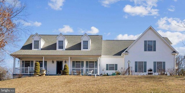 view of front of property featuring covered porch, a front lawn, and a shingled roof