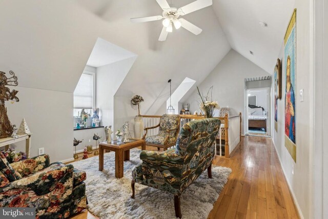 living area with vaulted ceiling, light wood-type flooring, and ceiling fan