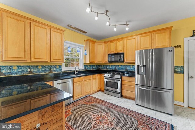 kitchen featuring appliances with stainless steel finishes, sink, and light brown cabinets