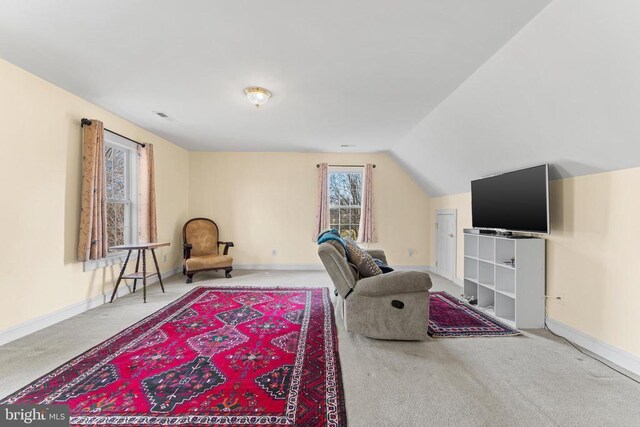 living area featuring carpet flooring and vaulted ceiling