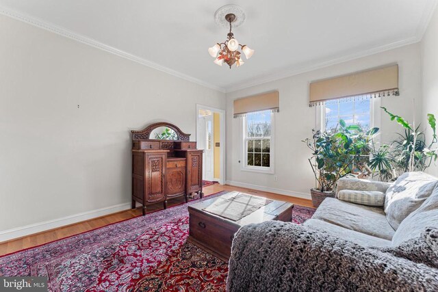 living room with a notable chandelier, crown molding, and hardwood / wood-style flooring