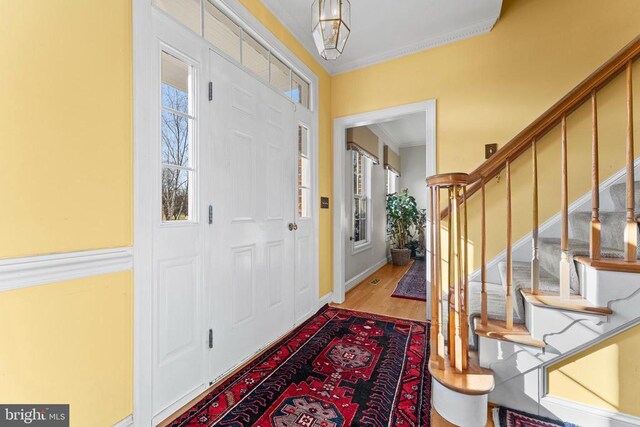 foyer with hardwood / wood-style floors and ornamental molding