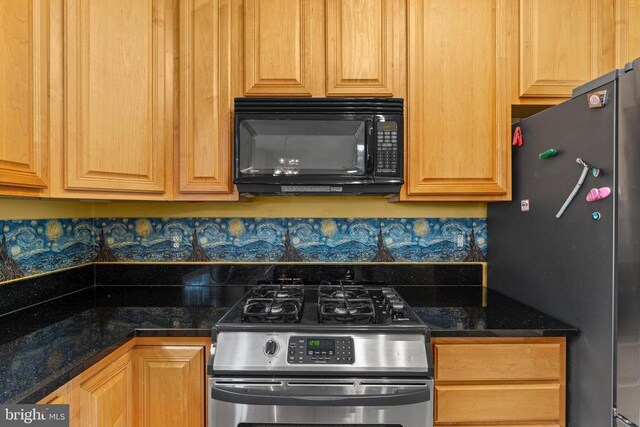 kitchen featuring appliances with stainless steel finishes and dark stone counters