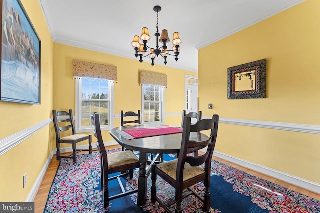 dining room with hardwood / wood-style floors, crown molding, and a chandelier