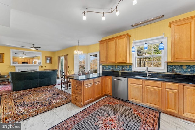 kitchen with stainless steel dishwasher, a healthy amount of sunlight, kitchen peninsula, and sink