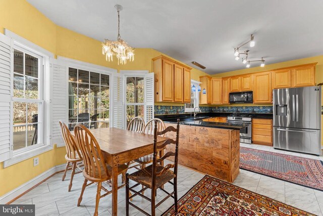 kitchen featuring appliances with stainless steel finishes, sink, a chandelier, and plenty of natural light