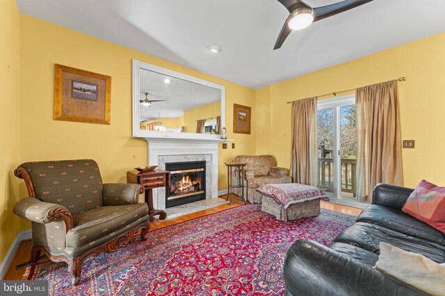 living room with ceiling fan, hardwood / wood-style floors, and a fireplace