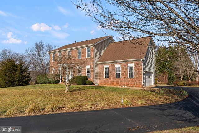 exterior space featuring a garage and a lawn