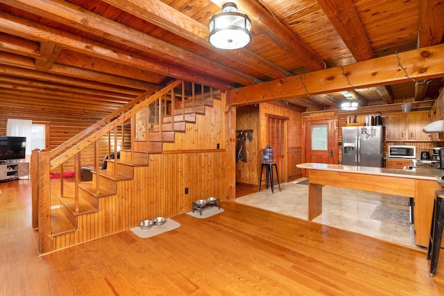 interior space featuring wooden ceiling, light wood-type flooring, wood walls, and stairs