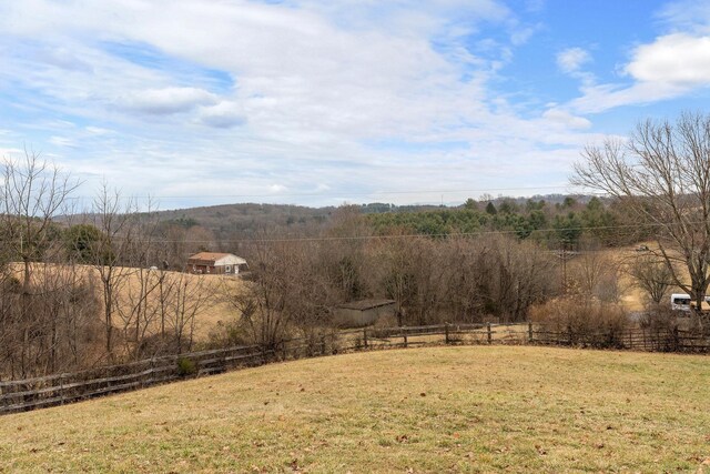 view of yard featuring a rural view and fence