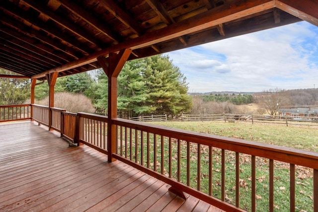 deck featuring a yard, a rural view, and a fenced backyard