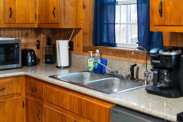 kitchen featuring light countertops, stainless steel microwave, and brown cabinets