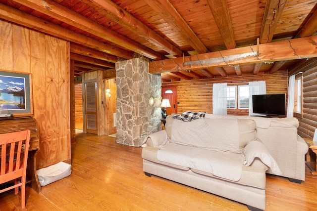 living area with wood finished floors, wood ceiling, rustic walls, and beam ceiling