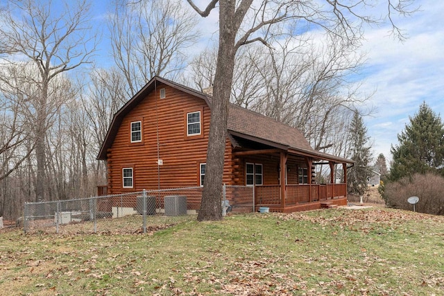 view of side of property featuring a yard, a gambrel roof, log siding, a shingled roof, and a porch