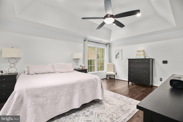  - bedroom with a tray ceiling, dark wood-style floors, ceiling fan, recessed lighting, and baseboards
