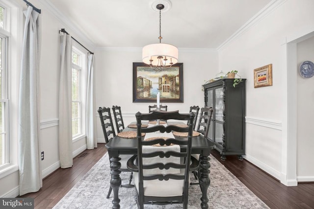  - dining area with a chandelier, dark wood-type flooring, ornamental molding, and baseboards