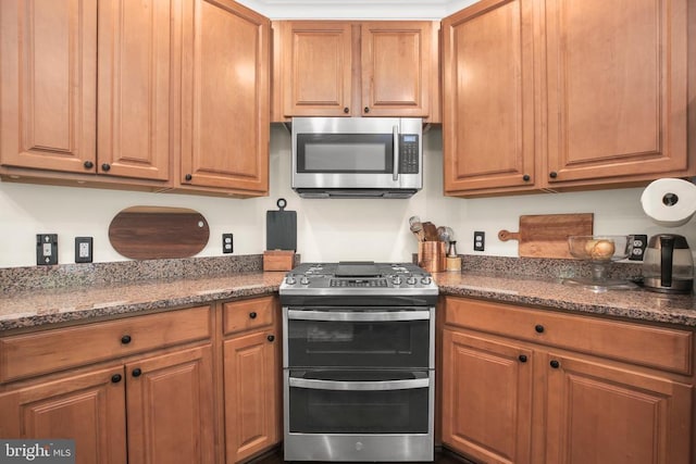  - kitchen featuring appliances with stainless steel finishes and brown cabinets