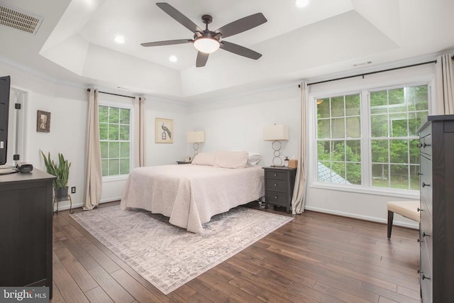  - bedroom with a tray ceiling, dark wood-style floors, baseboards, recessed lighting, and a ceiling fan