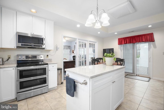 kitchen with stainless steel appliances, a chandelier, plenty of natural light, recessed lighting, and light tile patterned flooring