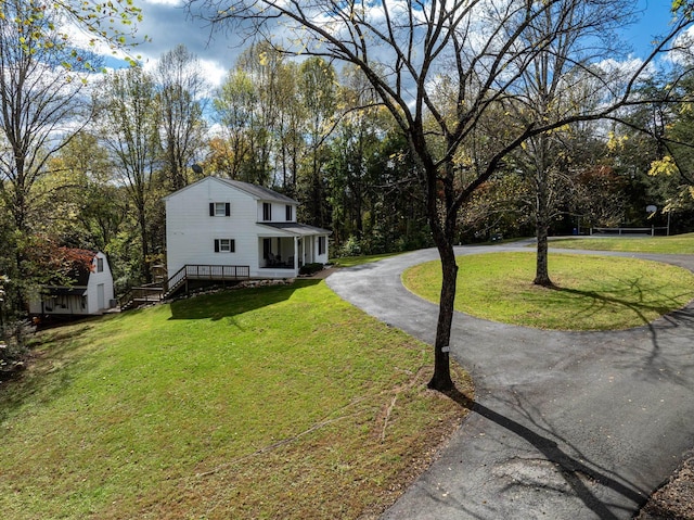 view of front of property with a front yard and a shed