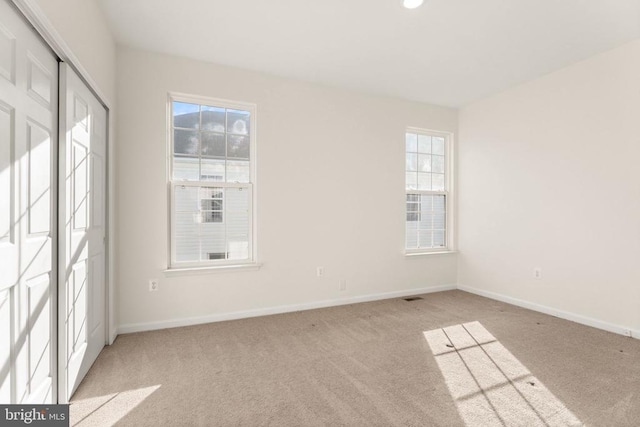  - spare room with plenty of natural light, carpet, and baseboards