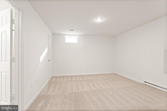  - basement featuring light colored carpet, a baseboard heating unit, and baseboards