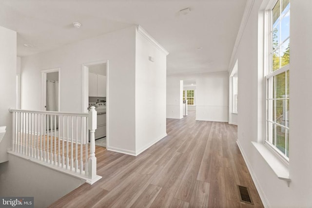  - corridor with wood finished floors, healthy amount of natural light, and baseboards