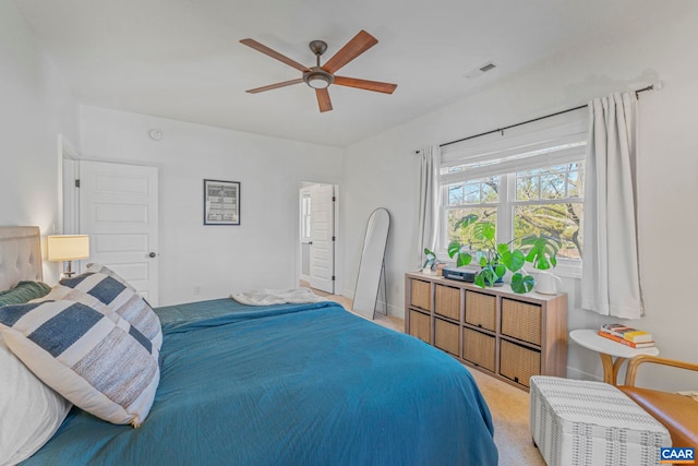 bedroom featuring light colored carpet, a ceiling fan, and visible vents