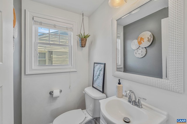 half bathroom featuring toilet and a sink