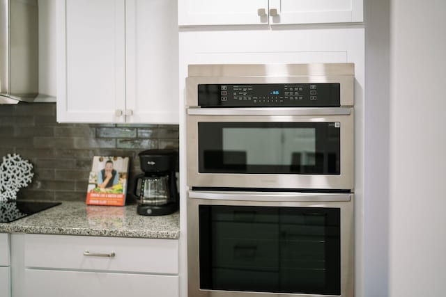 2003 Rinacas Corner Rd, Shenandoah, VA 22849 - kitchen with double oven, wall chimney range hood, black electric stovetop, decorative backsplash, and white cabinets
