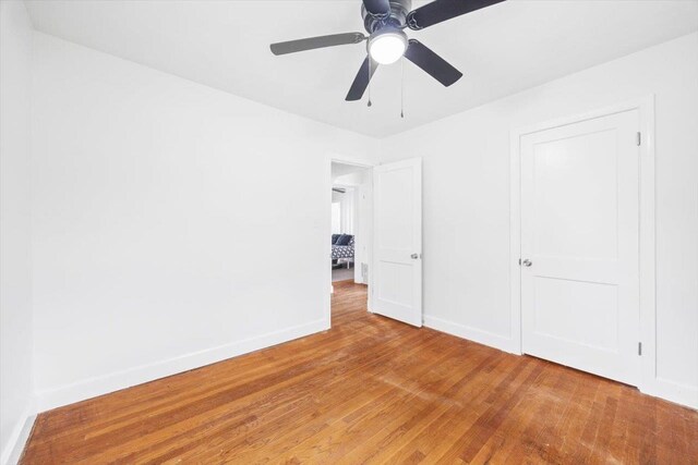 unfurnished bedroom with light wood-style flooring, baseboards, and a ceiling fan