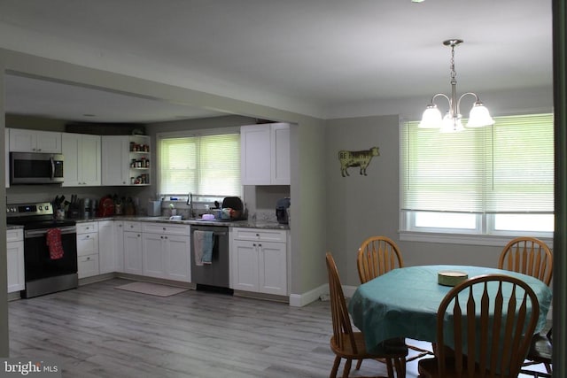 12134 Baylor Ln, Orange, VA 22960 - kitchen with appliances with stainless steel finishes, white cabinets, a chandelier, and light stone countertops