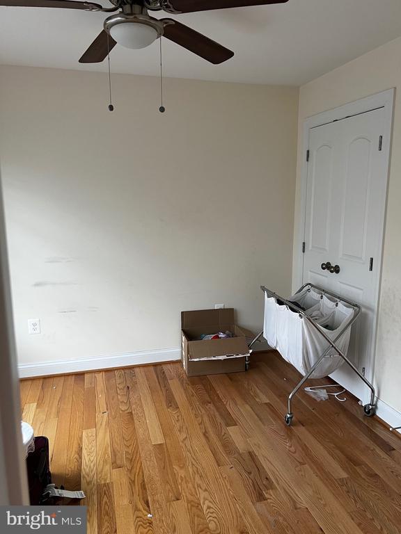 interior space featuring baseboards, a ceiling fan, and wood finished floors