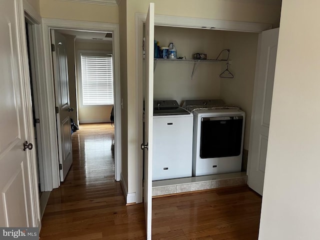 washroom with baseboards, laundry area, washing machine and dryer, and wood finished floors
