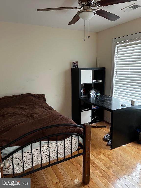 bedroom featuring visible vents, ceiling fan, and wood finished floors