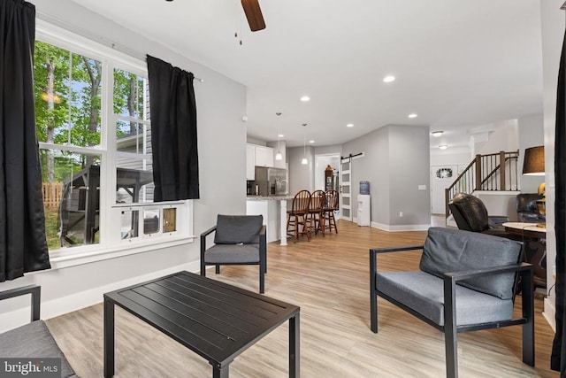 12929 Pipe Run Dr, Fredericksburg, VA 22407 - living area featuring a barn door, stairway, a ceiling fan, baseboards, and light wood finished floors