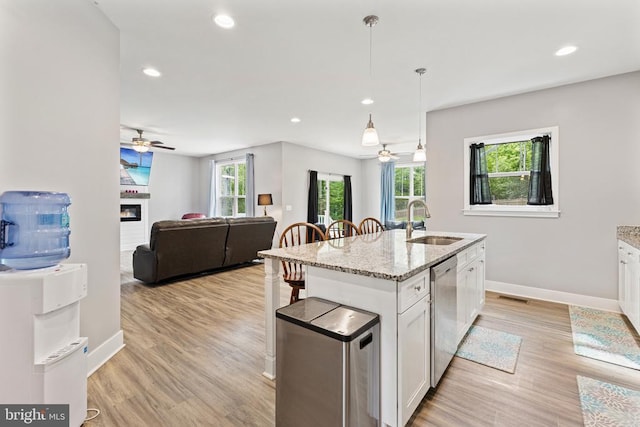 12929 Pipe Run Dr, Fredericksburg, VA 22407 - kitchen with a sink, dishwasher, a ceiling fan, white cabinets, and a glass covered fireplace