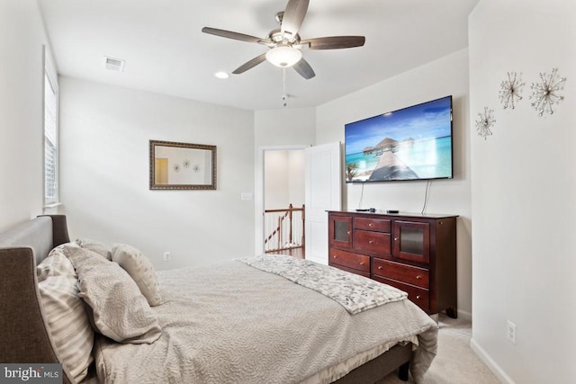 bedroom with a ceiling fan, light colored carpet, and baseboards