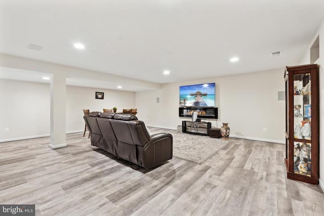 living area featuring light wood-type flooring, recessed lighting, and baseboards