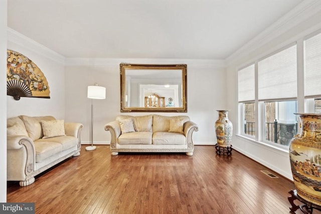 living room with wood-type flooring, crown molding, and baseboards