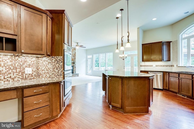 kitchen featuring appliances with stainless steel finishes, healthy amount of natural light, dark stone counters, and recessed lighting