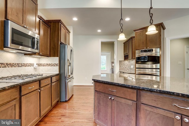 kitchen featuring stainless steel appliances, light wood-type flooring, decorative backsplash, decorative light fixtures, and recessed lighting