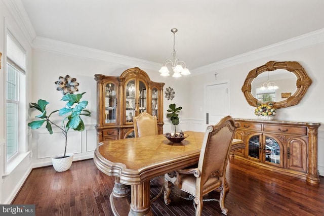dining area with a chandelier, wood finished floors, and crown molding
