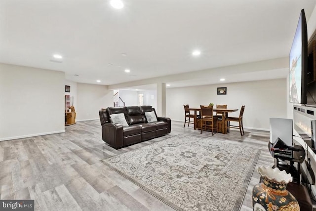 living room featuring wood finished floors, recessed lighting, and baseboards