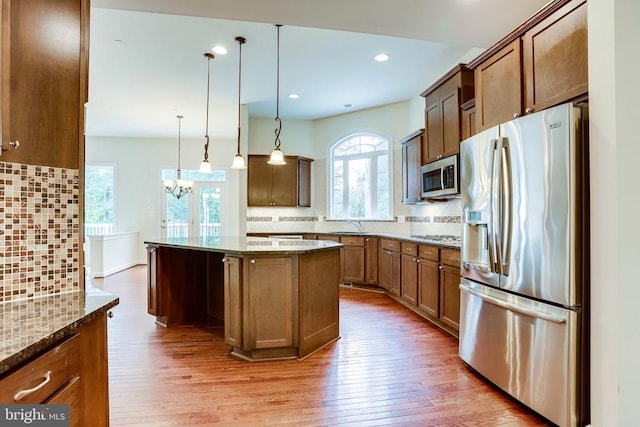 kitchen with stainless steel appliances, decorative backsplash, light stone counters, and recessed lighting