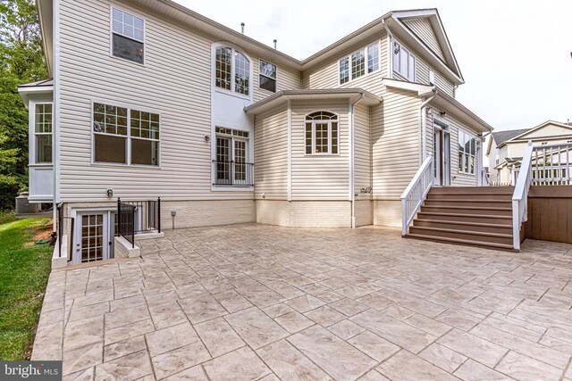 rear view of property with a patio and stairs