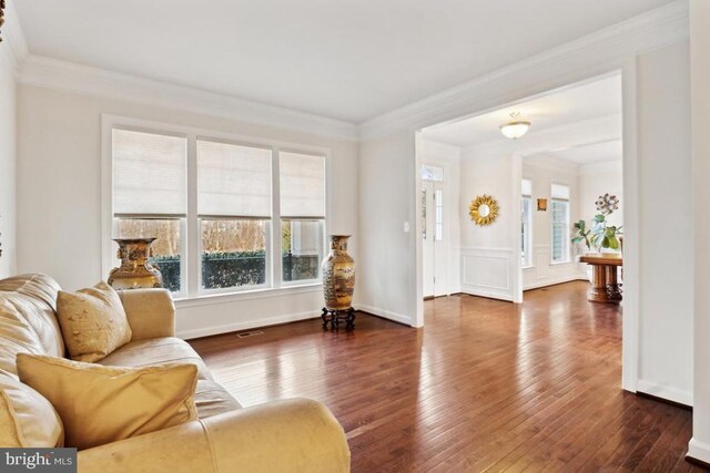 living room featuring ornamental molding and wood-type flooring