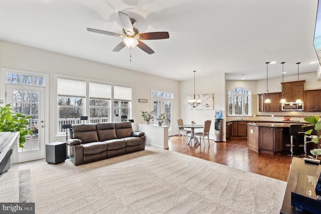 living room featuring a chandelier, plenty of natural light, a ceiling fan, dark wood-style flooring, and recessed lighting